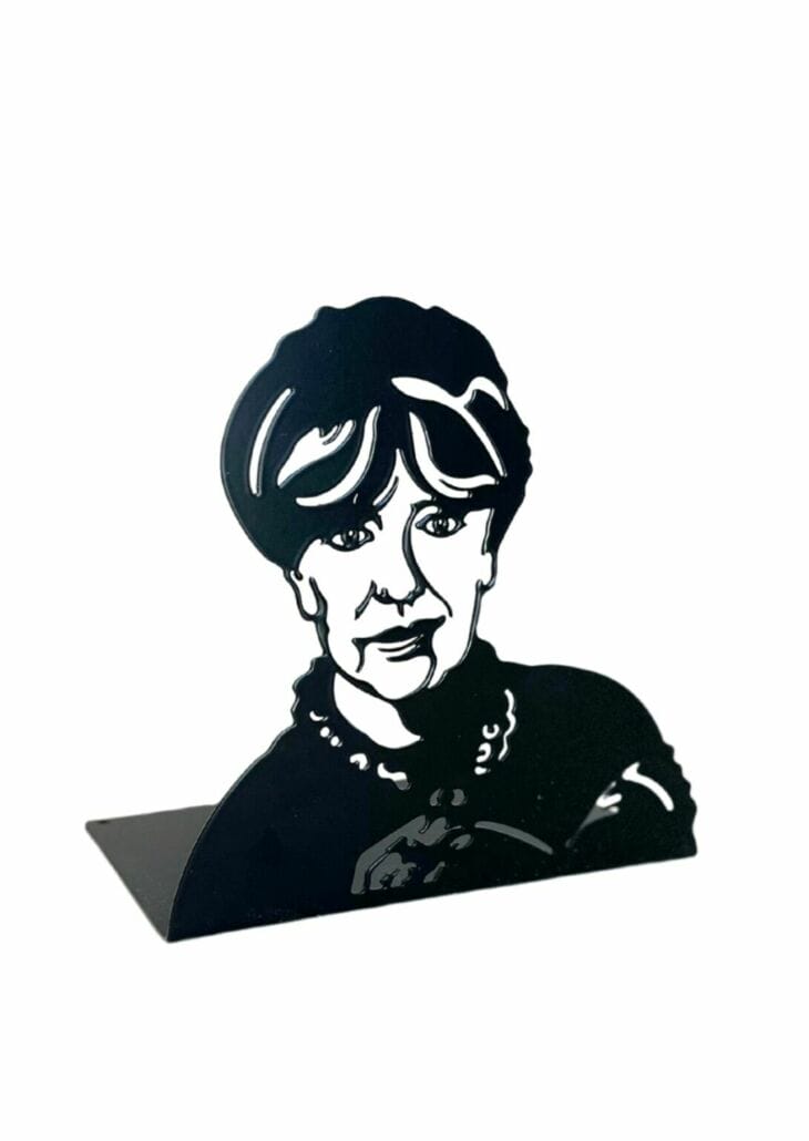 Suzanne Brøgger (f. 1944) debuterede i 1973 med essaysamlingen Fri os fra kærligheden. Hun har efterfølgende skrevet en lang række romaner, essays og digte som ofte omhandler seksualitet, kønsroller og kvinden i det moderne samfund. Hendes værker afspejler både hendes eget livs omskiftelser og samtidig årtier, hvor holdninger, moral og samlivsformer har været i konstant opbrud. Brøgger har modtaget mange litterære priser og i 1985 blev hun desuden tildelt Statens Kunstfonds livsvarige ydelse.

Bag idé og design af Novellix forfatterbogstøtter står den svenske industridesigner Jan Landqvist. Bogstøtterne fremstilles i Gnosjö i Sverige og er lavet af udskåret, bukket stål og  behandlet med en sort, bæredygtig pulverlak.

Mål
15×15 cm for portræt og 10×15 cm for bundpladen.